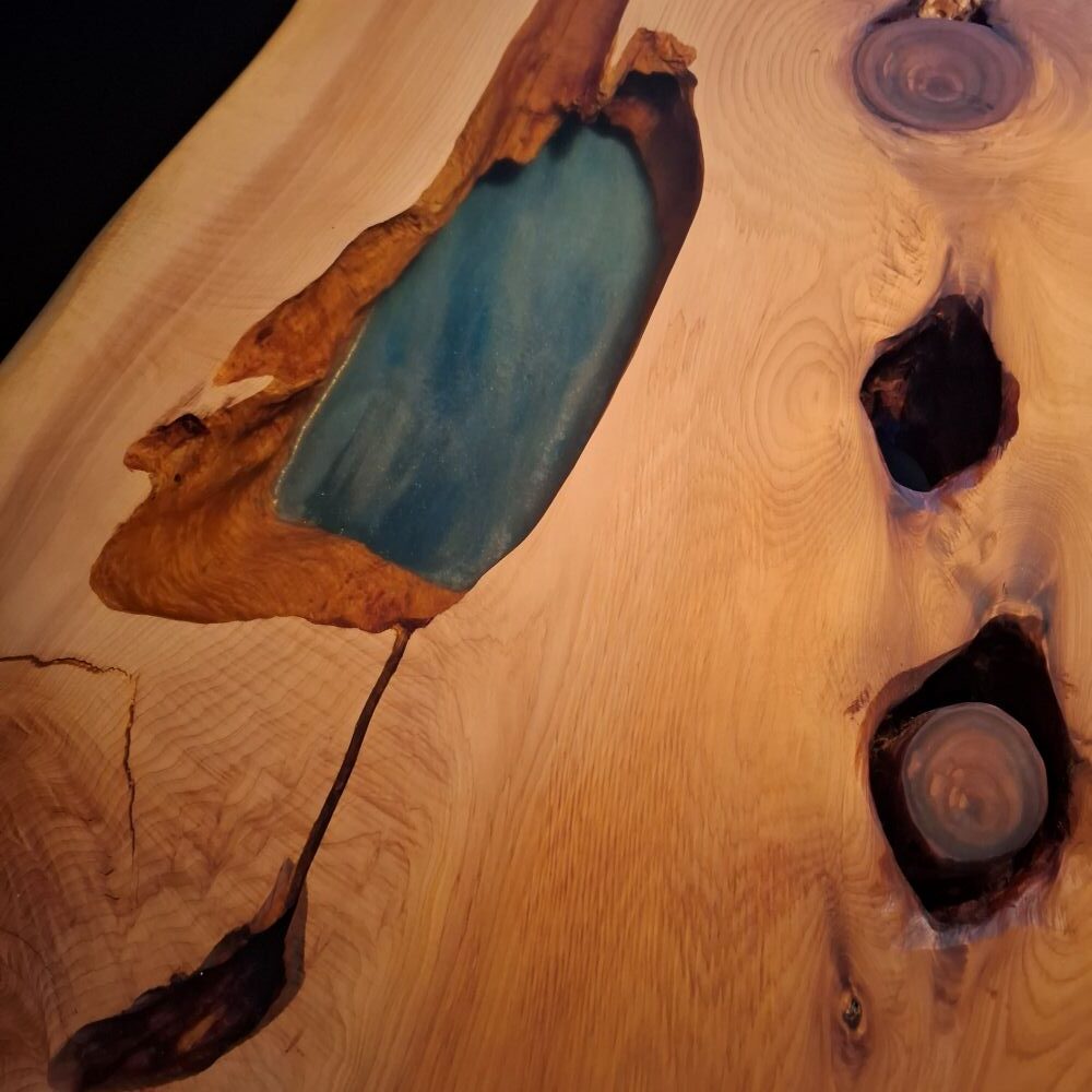 Table bord naturel en genévrier massif avec résine époxy bleue